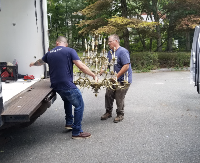 men caring an old chandelier to a loading truck
